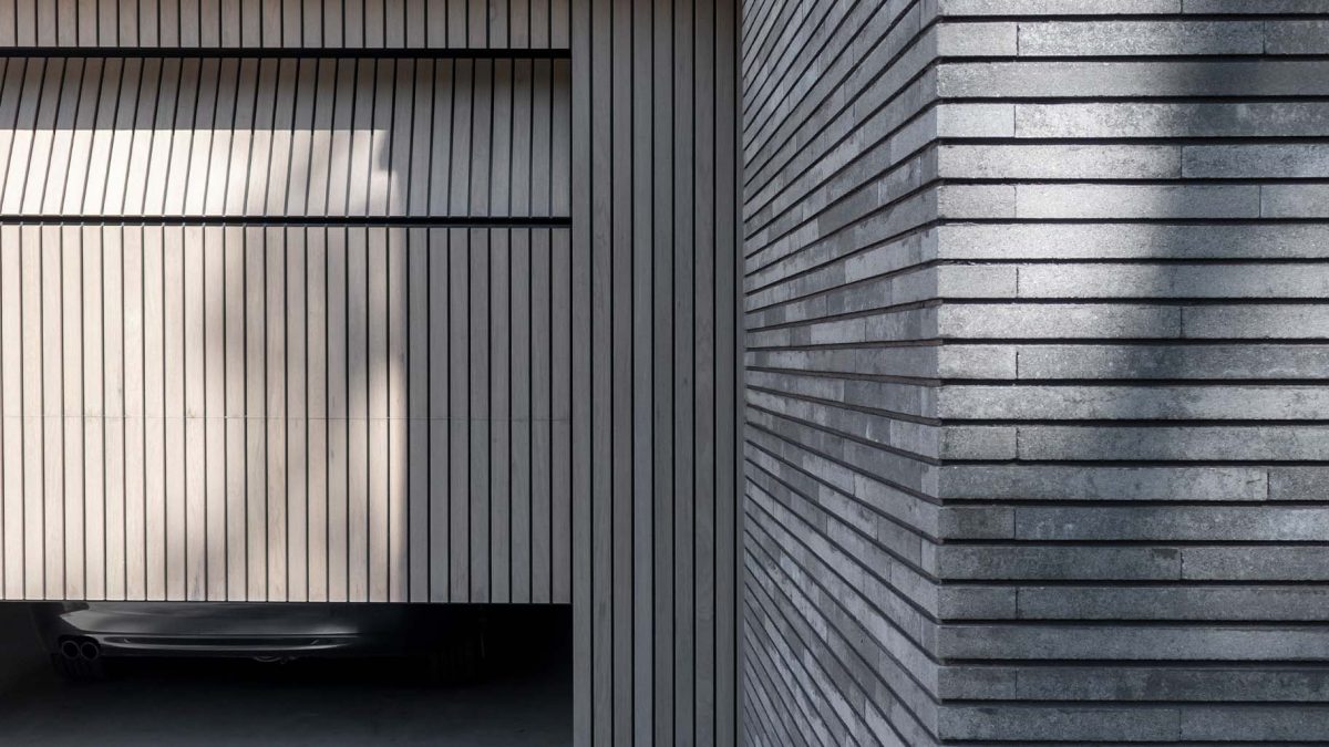 Verticale frake hout garagedeur gelijk met de gevel | Different Doors