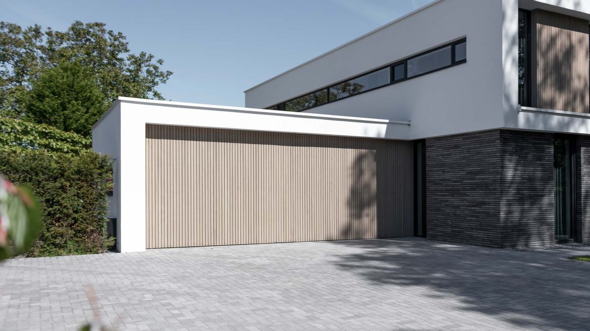 Verticale frake hout garagedeur gelijk met de gevel | Different Doors