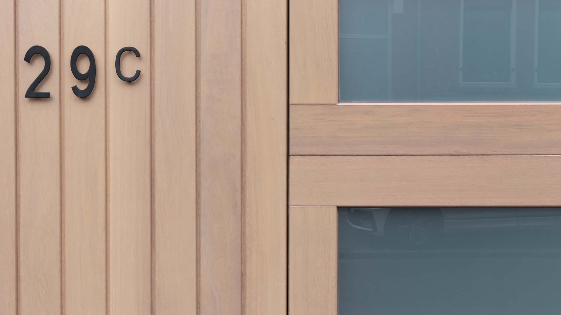 Houten sectionaaldeur en voordeur in Iroko hout