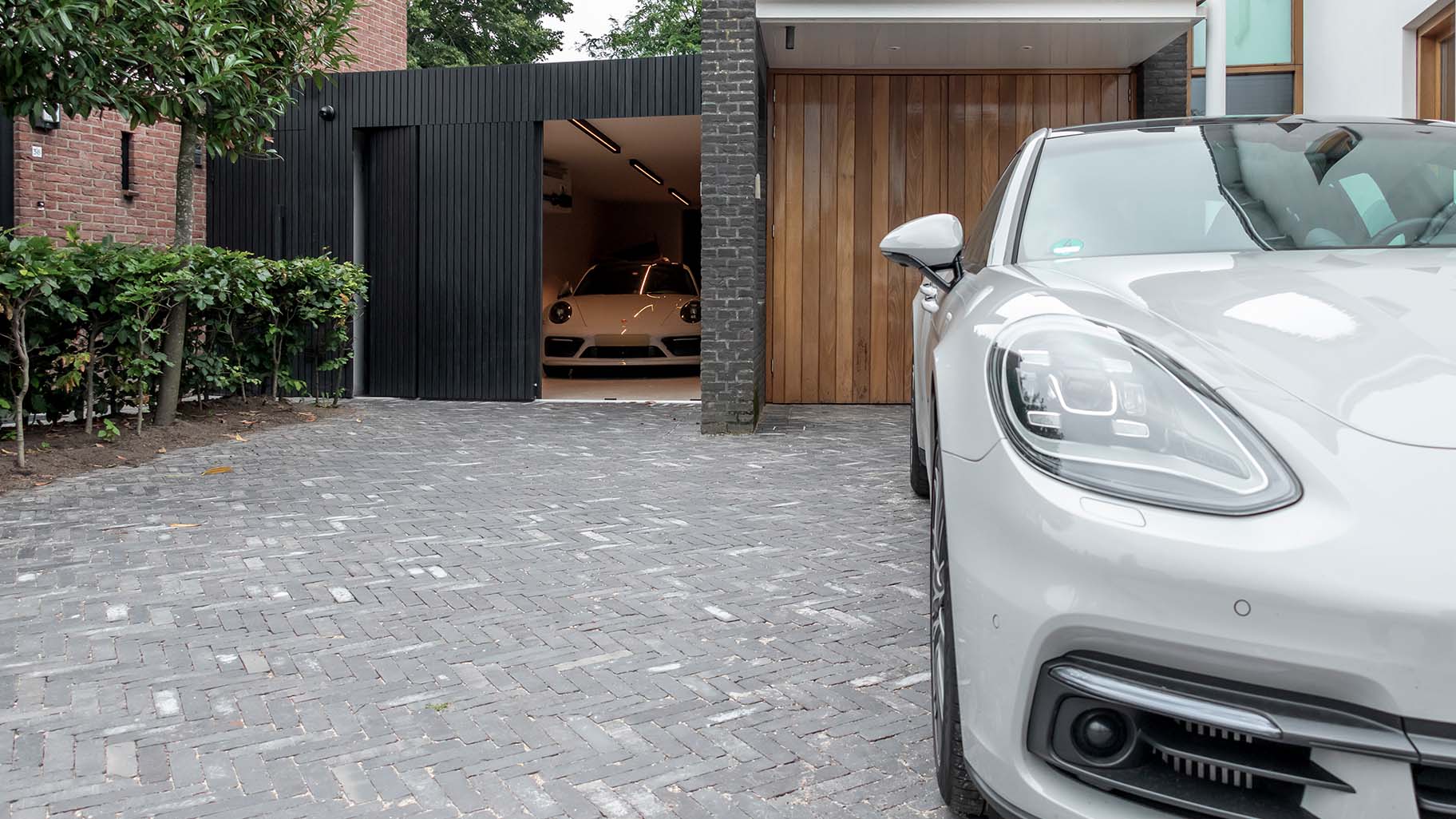 Op maat gemaakte zwarte houten zijwaartse garagedeur, gerealiseerd door Different Doors