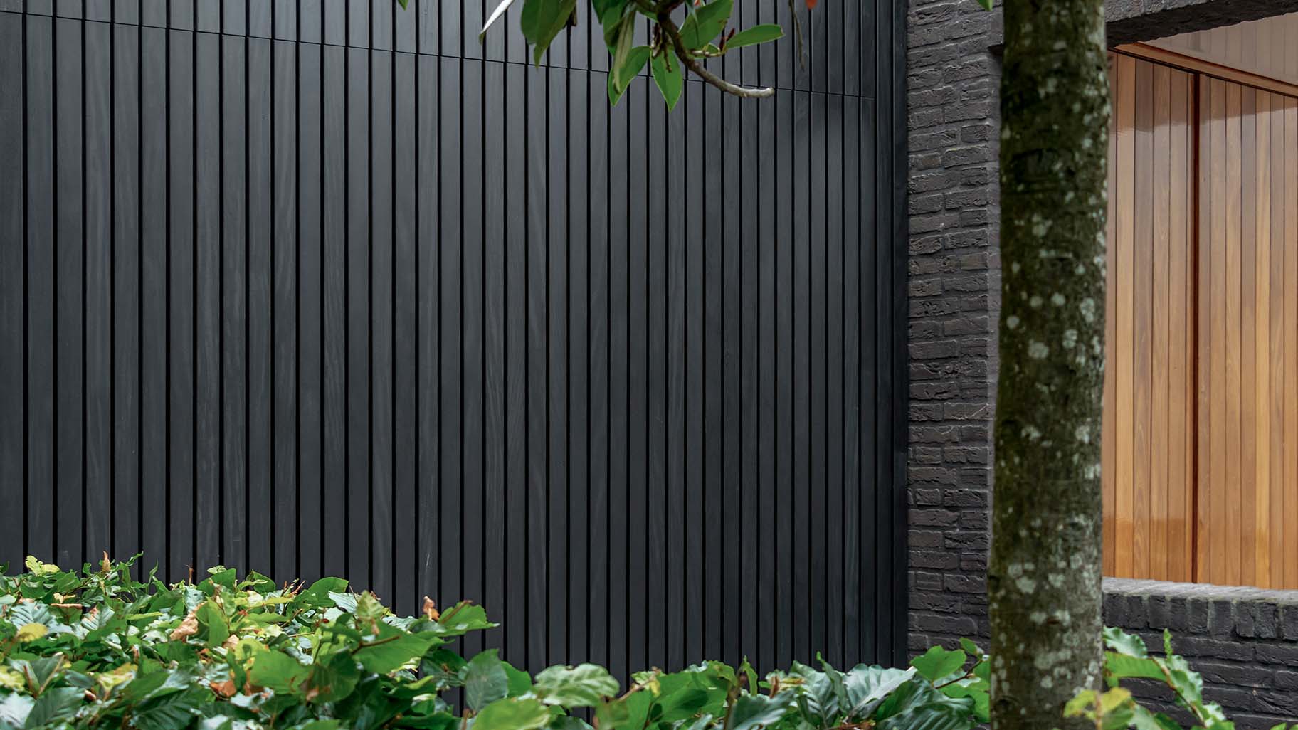 Zwarte Afrormosia houten garagedeur met verticale latten