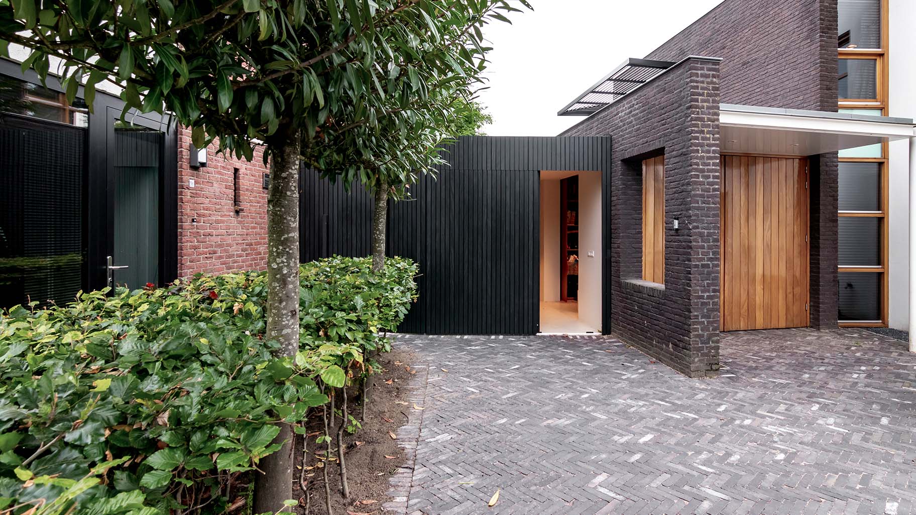 Zwarte Afrormosia houten garagedeur met verticale latten