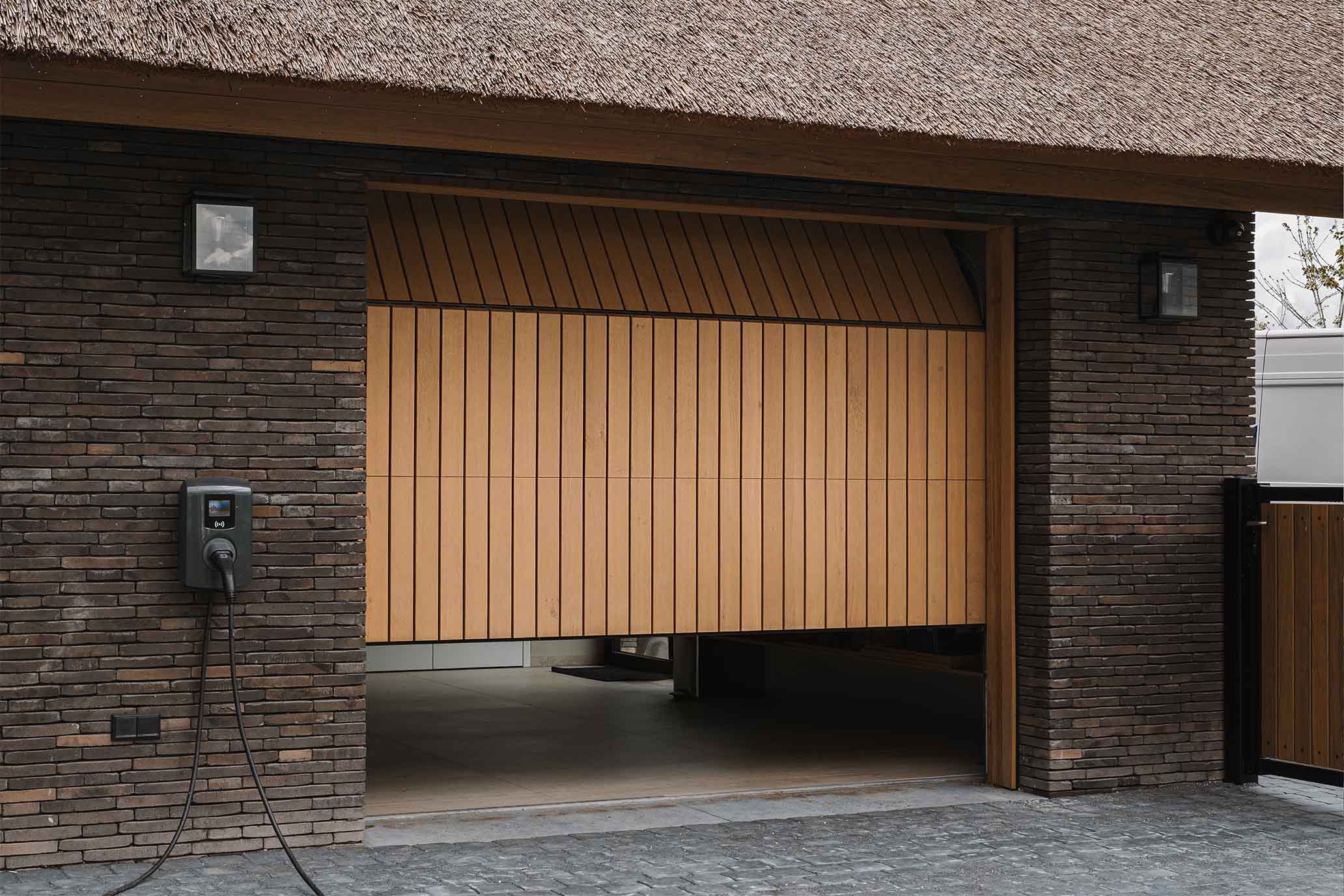 Modern landelijke villa met rieten kap en een eikenhouten garagedeur