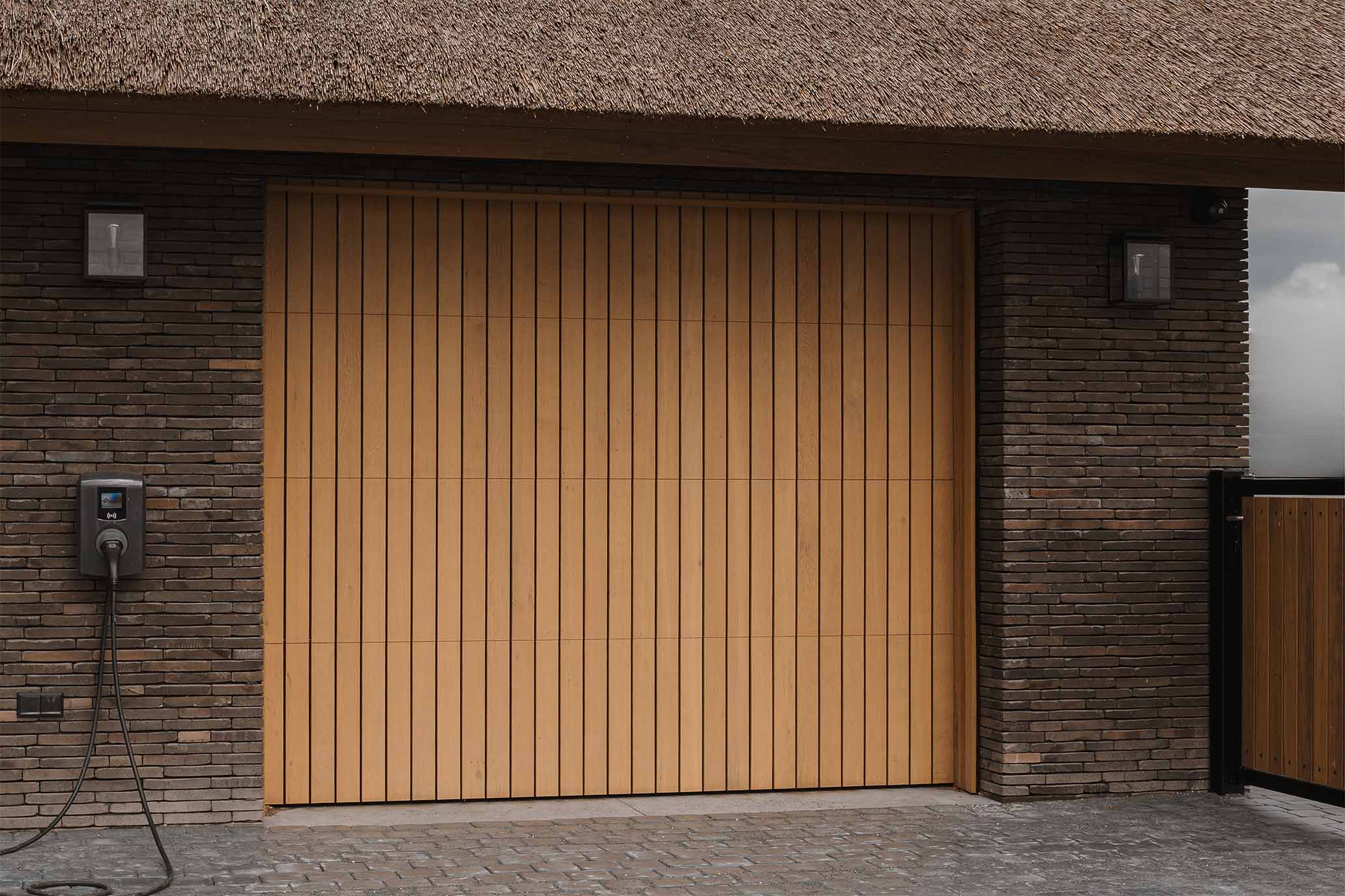 Modern landelijke villa met rieten kap en een eikenhouten garagedeur