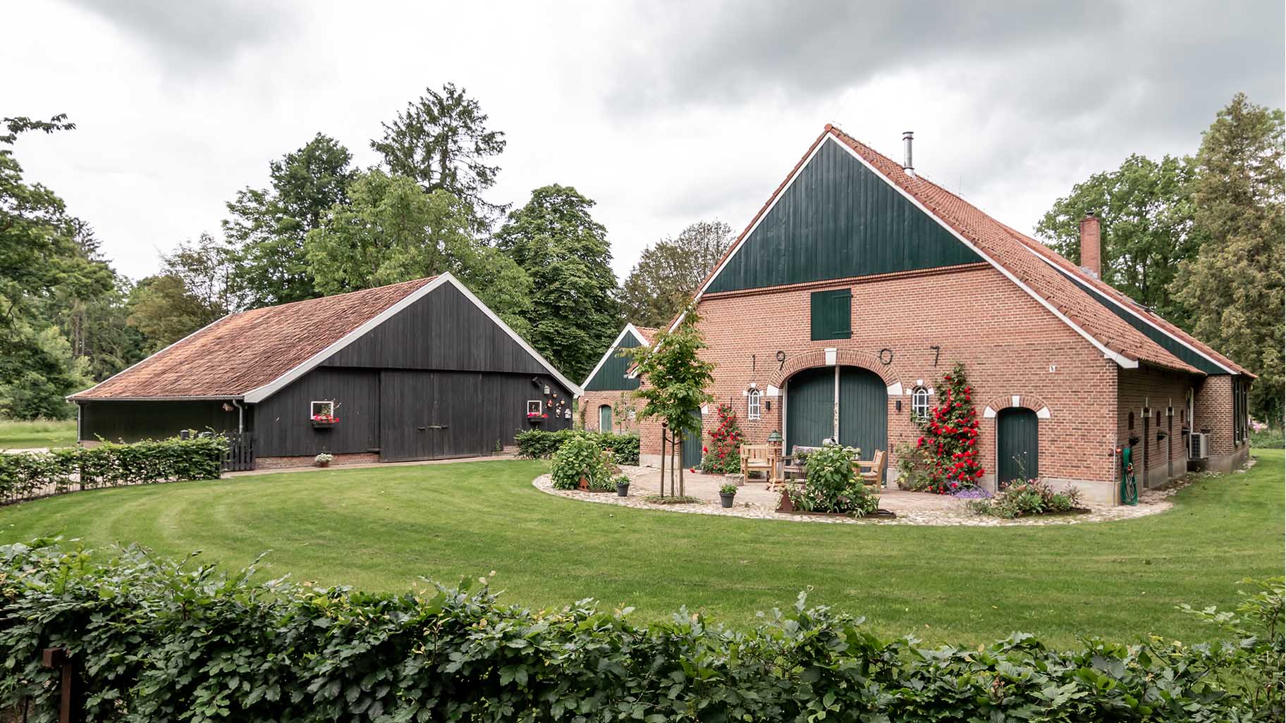 Houten garagedeur bij klassieke boerderij