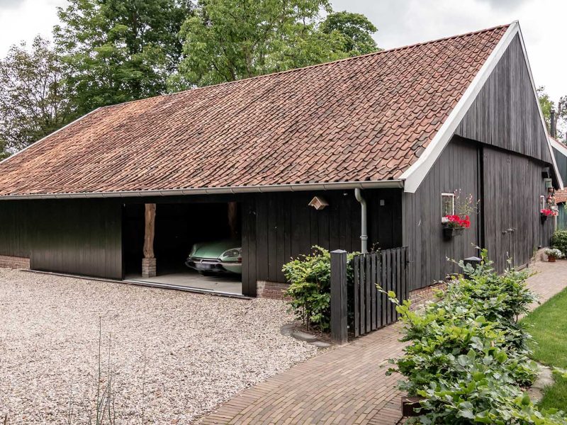 Houten garagedeur bij klassieke boerderij