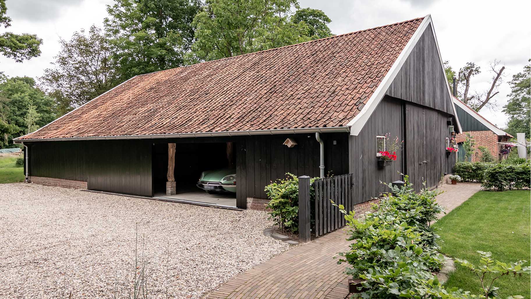 Houten garagedeur bij klassieke boerderij
