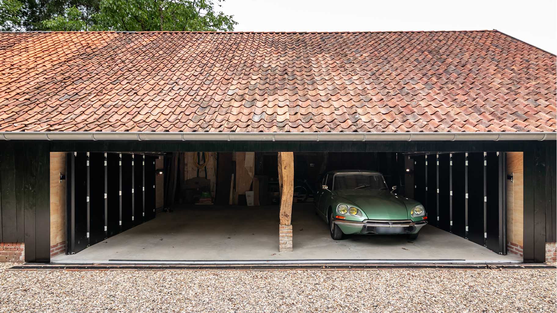 Houten garagedeur bij klassieke boerderij